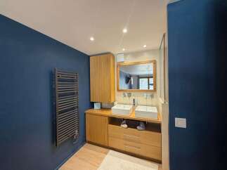 This modern bathroom features a sleek design with a double vanity, complete with two square vessel sinks and modern faucets.