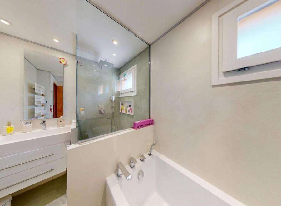 Experience modern luxury in this stunning bathroom featuring a sleek vanity with ample storage and a pristine white countertop.