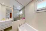 Experience modern luxury in this stunning bathroom featuring a sleek vanity with ample storage and a pristine white countertop.
