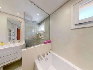Experience modern luxury in this stunning bathroom featuring a sleek vanity with ample storage and a pristine white countertop.