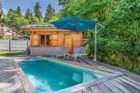 Escape to this serene backyard oasis featuring a sparkling swimming pool surrounded by a spacious wooden deck.