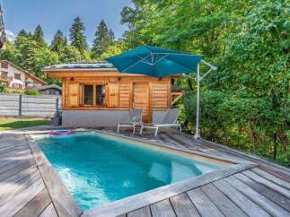 Escape to this serene backyard oasis featuring a sparkling swimming pool surrounded by a spacious wooden deck.