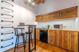 This charming studio apartment features a compact kitchenette with rustic wooden cabinetry, a mini-fridge, and a microwave, perfect for preparing simple meals.