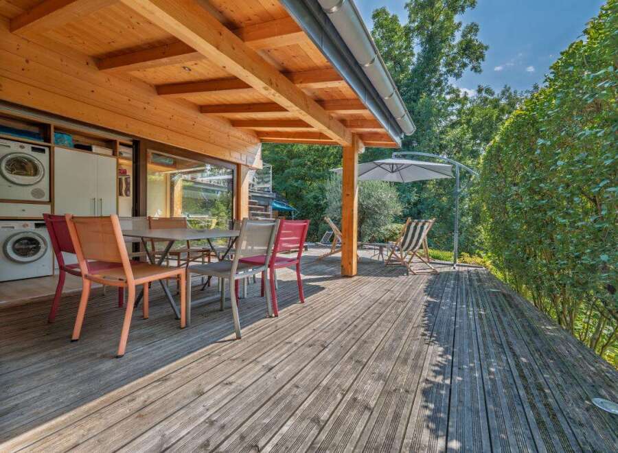Enjoy outdoor living on this spacious wooden deck, perfect for al fresco dining with a table and chairs.