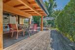 Enjoy outdoor living on this spacious wooden deck, perfect for al fresco dining with a table and chairs.