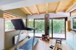 This home gym features a spacious workout area with a treadmill, punching bag, and rowing machine, perfect for a comprehensive fitness routine.