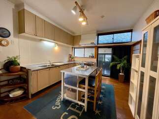This spacious kitchen features ample cabinet storage and a sleek stainless steel countertop, perfect for meal preparation.