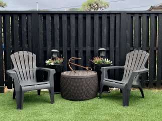 Enjoy your outdoor oasis with this charming patio set, featuring two comfortable Adirondack chairs and a stylish barrel-shaped side table.
