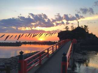 Experience breathtaking sunsets from this unique property, featuring a picturesque bridge leading to a scenic island with a lighthouse.
