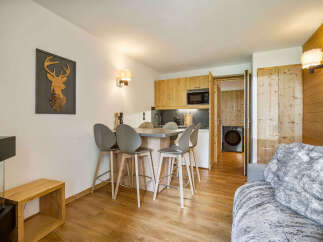 Experience modern mountain living in this stylish apartment, featuring a sleek kitchen island with bar stools perfect for casual dining.