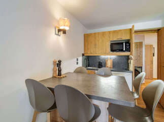 Enjoy a cozy meal in this charming dining area, featuring a modern stone-top table and comfortable seating.