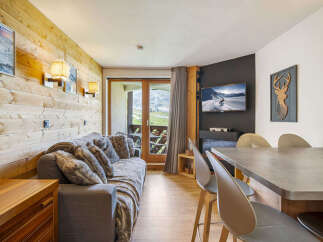 Experience cozy mountain living in this charming apartment, featuring a comfortable sofa adorned with plush throws and decorative pillows.