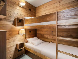 Experience cozy mountain living with this charming bunk bed setup, perfect for a ski chalet or cabin retreat.