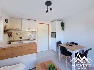 Discover this charming studio apartment featuring a modern, compact kitchen with ample cabinet space and a sleek countertop.