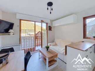 Discover this charming apartment with a bright living area, featuring a comfortable sofa and a coffee table perfect for relaxing.