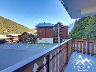 Enjoy stunning mountain views from this charming apartment balcony, overlooking a well-maintained parking area and traditional alpine architecture.