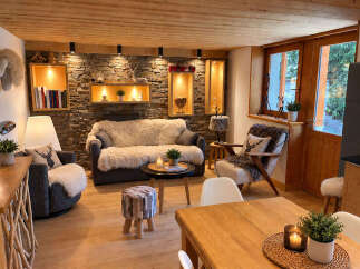 Experience cozy mountain living in this charming living room, featuring a stone accent wall and warm wooden ceilings.