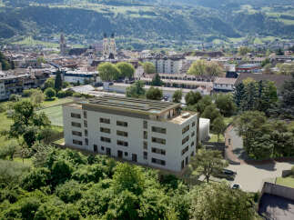 Discover modern living in this stunning apartment building, featuring a rooftop terrace with panoramic views and solar panels for sustainable energy.