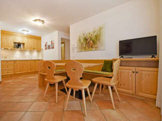 This charming dining area features a cozy wooden banquette seating arrangement, perfect for family meals.