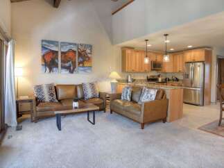 Experience comfortable living in this inviting open-concept space, featuring plush leather sofas and a striking triptych artwork of a moose.