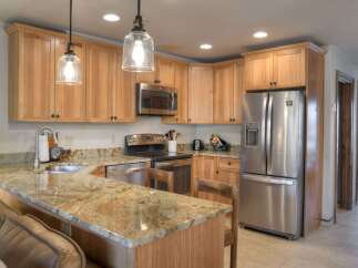 This spacious kitchen features beautiful light wood cabinetry and granite countertops, offering a warm and inviting atmosphere.