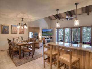 Experience comfortable living in this open-concept space, featuring a dining area with a charming chandelier and a spacious kitchen island perfect for entertaining.