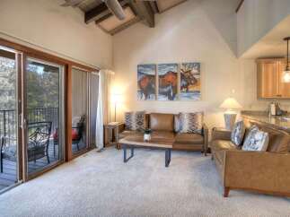 Experience mountain living in this stunning living room featuring plush leather sofas and a rustic wood coffee table.