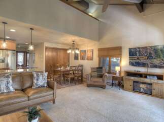 Experience comfortable living in this spacious open-concept living area, featuring a cozy leather sofa and a dedicated dining space perfect for family meals.