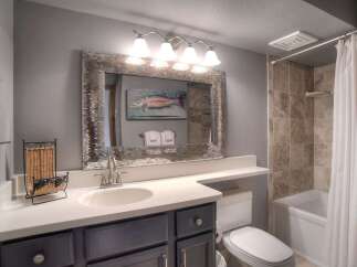 This charming bathroom features a spacious vanity with a modern sink and ample counter space, perfect for your morning routine.