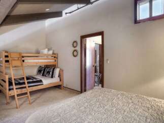This charming bedroom features a cozy bunk bed with playful bear-themed bedding, perfect for accommodating guests or children.