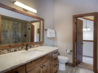 This bathroom features a stunning vanity with a stone accent backsplash and a large wooden-framed mirror.