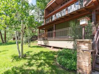 Experience mountain living in this stunning home, featuring a spacious covered deck perfect for enjoying the serene surroundings.