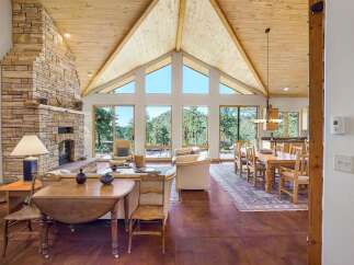 Experience breathtaking mountain views from this stunning great room, featuring a soaring vaulted ceiling and a magnificent stone fireplace.