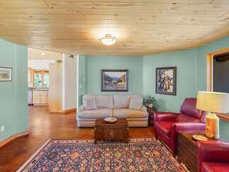 Step into this inviting living space featuring a comfortable sofa and plush red armchairs, perfect for relaxation.