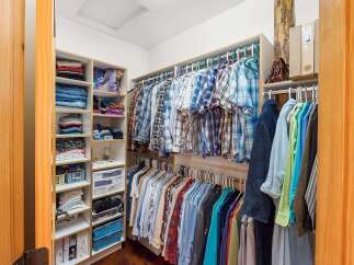 Discover ample storage in this well-organized walk-in closet, featuring extensive shelving and multiple hanging racks.