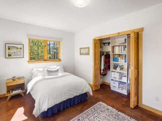 Discover this charming bedroom featuring a comfortable queen-sized bed with crisp white linens and a decorative throw pillow.