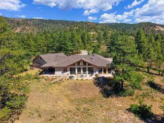 Nestled amidst a serene forest landscape, this stunning home offers breathtaking mountain views and a tranquil retreat.