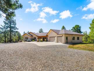 Discover this stunning home nestled amidst mature pine trees, offering a serene and private retreat.