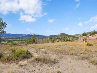 Discover breathtaking mountain views from this expansive property, offering a serene escape with a backdrop of rolling hills and a distant snow-capped peak.