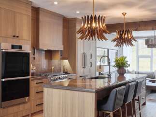 Experience luxury in this stunning modern kitchen, featuring sleek wood cabinetry and a spacious island perfect for entertaining.
