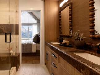 Experience luxury in this master bathroom featuring a stunning double vanity with rich wood cabinetry and marble countertops.