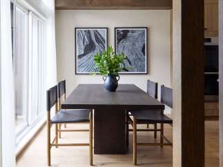 Experience elegant dining in this sophisticated space, featuring a dark wood table complemented by minimalist leather chairs.