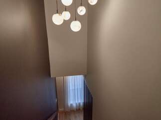 Experience modern elegance with this stunning staircase featuring a unique globe pendant light fixture.