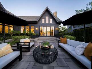 Experience luxurious outdoor living with this stunning patio featuring comfortable seating and elegant landscaping.