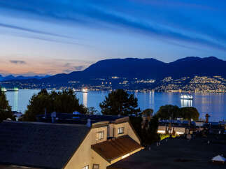 Experience breathtaking twilight views from this stunning property overlooking the water and distant city lights.