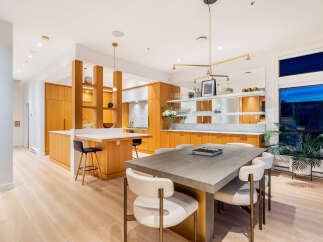 Experience modern living in this stunning open-concept kitchen and dining area, featuring sleek wooden cabinetry and a spacious island perfect for entertaining.