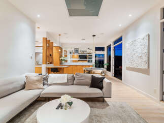 Experience modern living in this stunning open-concept space, featuring a sleek sectional sofa and a contemporary dining area.