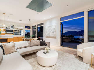 Experience luxurious living in this stunning modern home, featuring an open-concept living area with a sectional sofa and a stylish coffee table.