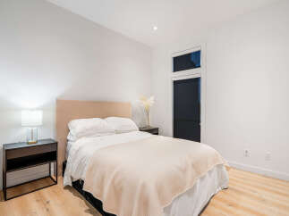 Experience comfort and style in this beautifully appointed bedroom, featuring a plush bed with crisp white linens and a soft, neutral-toned throw.