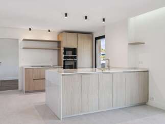 Experience modern living in this stunning kitchen featuring a sleek island with ample storage and a built-in sink.